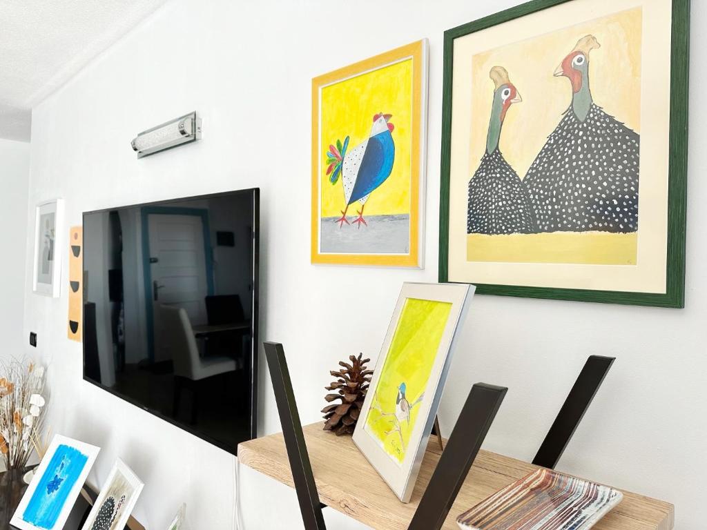 a room with paintings on the wall and a table with a painting at Relaxing Ocean View, Spacious Art Apartment With Large Terrace, Near Best Costa Adeje Beaches in Adeje