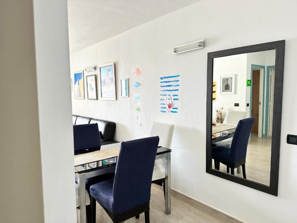 a mirror in a room with a desk and chairs at Relaxing Ocean View, Spacious Art Apartment With Large Terrace, Near Best Costa Adeje Beaches in Adeje
