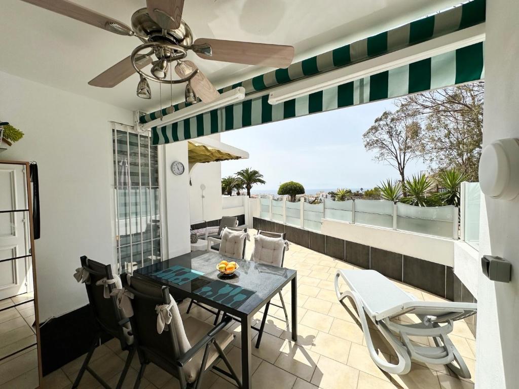 a patio with a table and chairs on a balcony at Relaxing Ocean View, Spacious Art Apartment With Large Terrace, Near Best Costa Adeje Beaches in Adeje