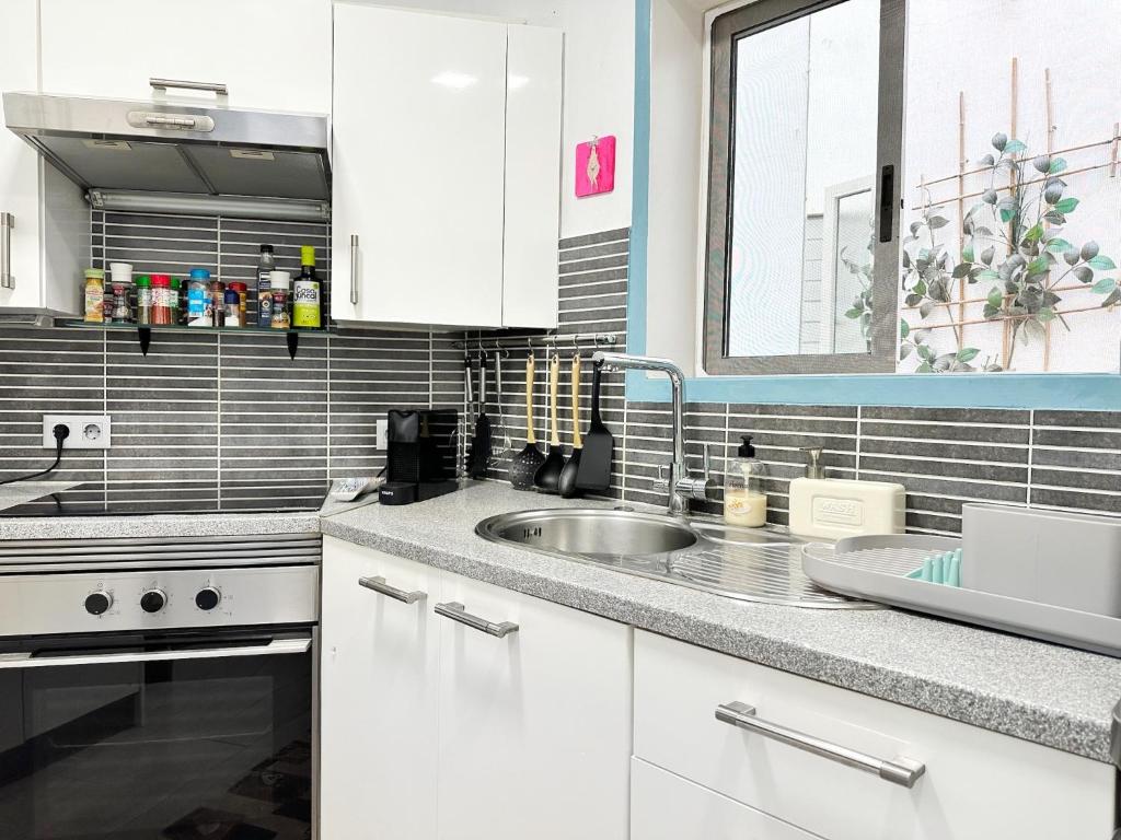 a kitchen with white cabinets and a sink at Relaxing Ocean View, Spacious Art Apartment With Large Terrace, Near Best Costa Adeje Beaches in Adeje