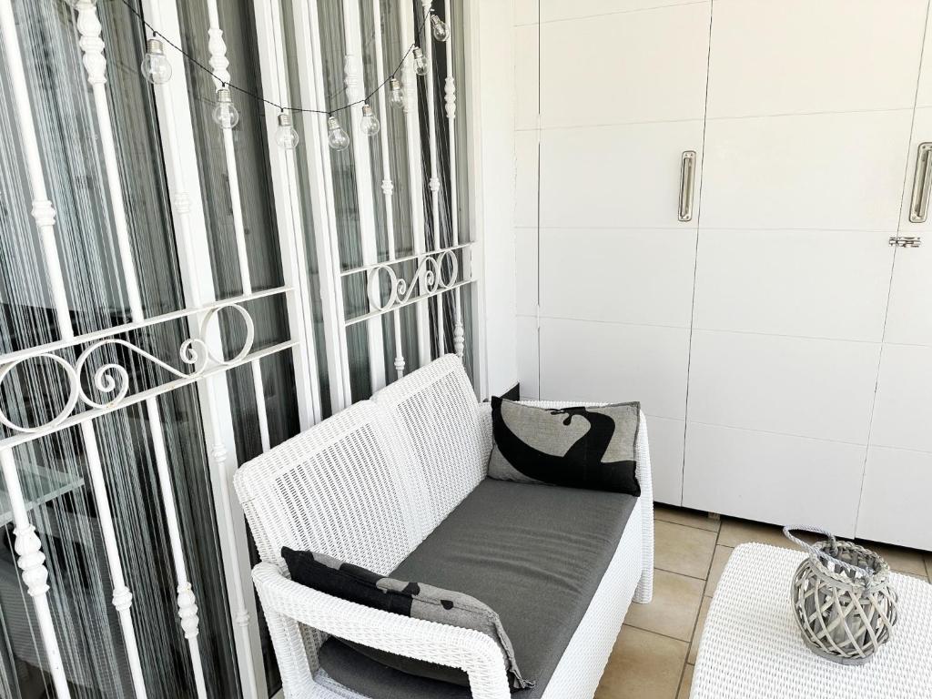 a white wicker chair sitting in a room at Relaxing Ocean View, Spacious Art Apartment With Large Terrace, Near Best Costa Adeje Beaches in Adeje