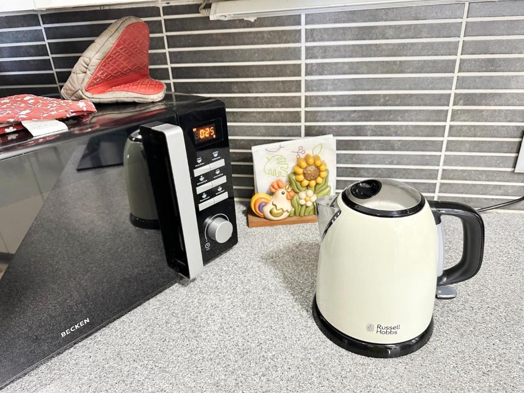 a coffee maker on a counter next to a microwave at Relaxing Ocean View, Spacious Art Apartment With Large Terrace, Near Best Costa Adeje Beaches in Adeje