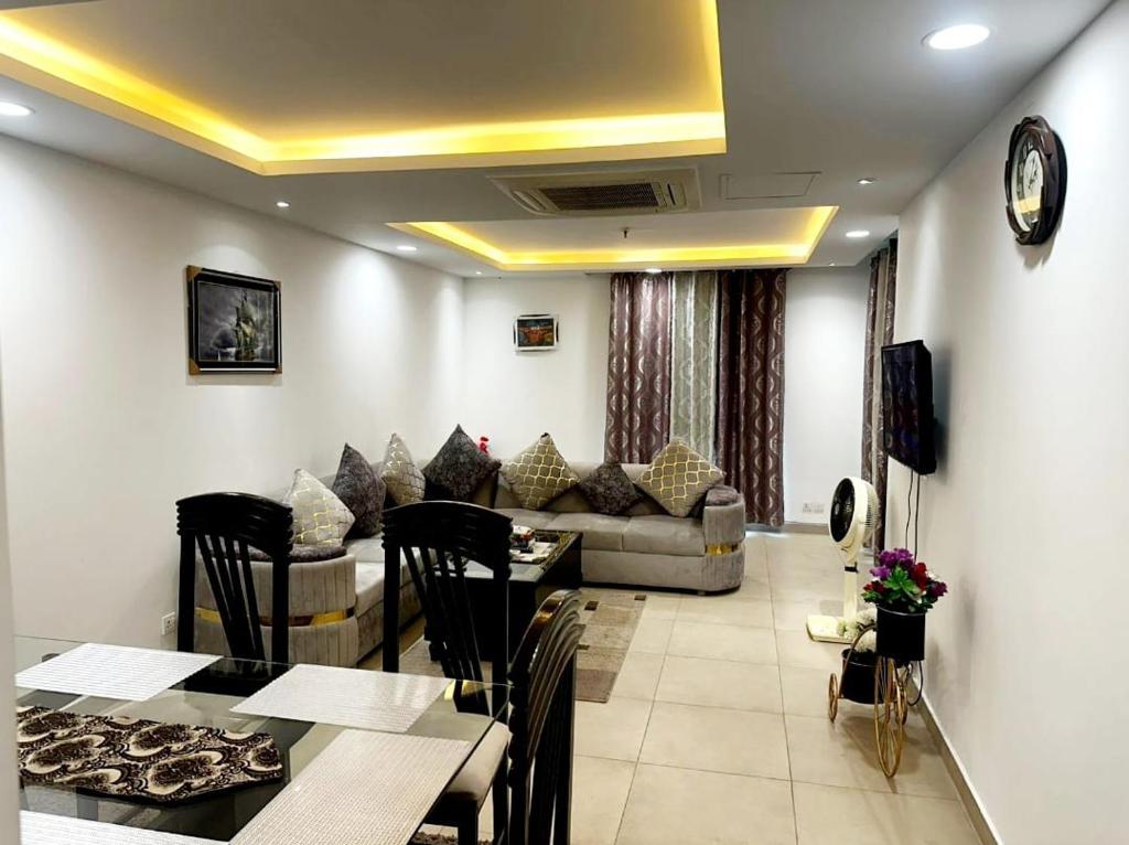 een woonkamer met een tafel en een bank bij 2 bed Apartment in Gold crest apartment in Lahore