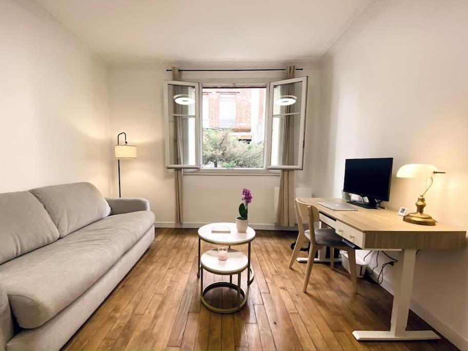 - un salon avec un canapé et un bureau avec un ordinateur dans l'établissement Charming Vincennes Apartment, à Vincennes