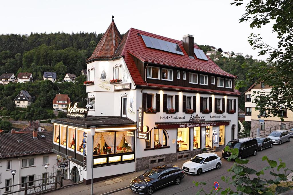 een groot wit gebouw met een rood dak op een straat bij Hotel Restaurant Ketterer am Kurgarten in Triberg