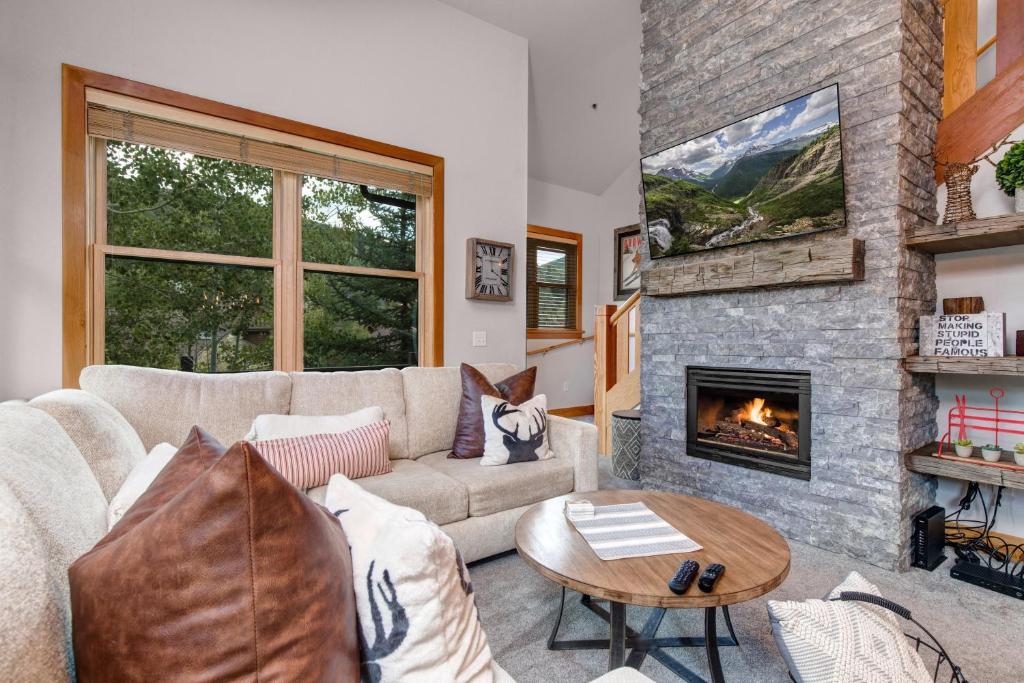 a living room with a couch and a fireplace at Unbeatable Location, Year-Round Recreation & Private Hot Tub! Deer Valley Greyhawk 14 in Park City