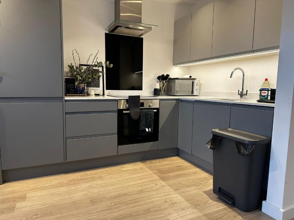 una cocina con electrodomésticos de acero inoxidable y un cubo de basura en Beckenham- PRIVATE DOUBLE Bedroom With En-suite in SHARED APARTMENT, en Elmers End