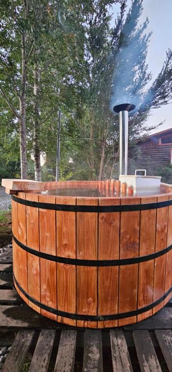 - un bain à remous en bois installé au-dessus d'une terrasse en bois dans l'établissement Rustico Pucon, à Pucón