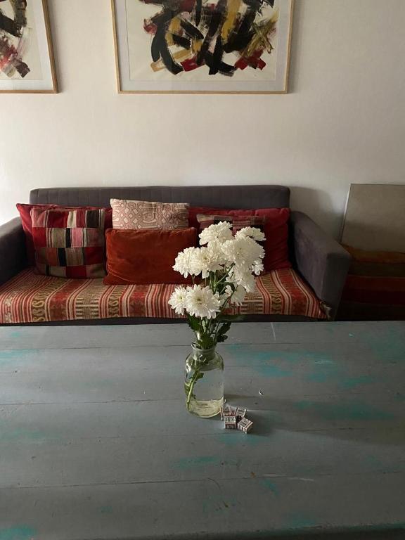 un jarrón de flores sobre una mesa en la sala de estar en La Casita de Bogado en Boulogne