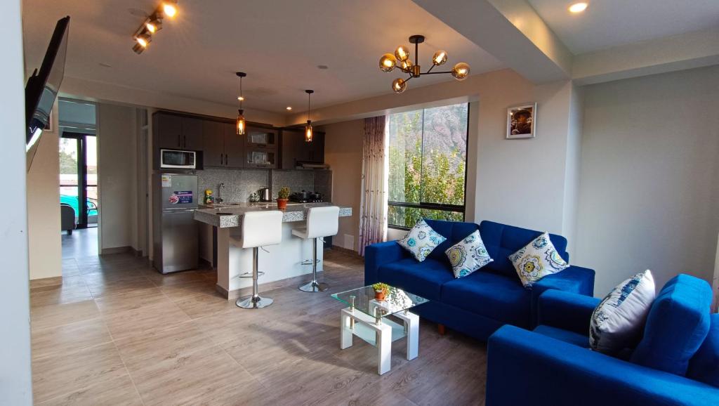 Il comprend un salon avec un canapé bleu et une cuisine. dans l'établissement PACHAMAMA ROOMS, à Urubamba