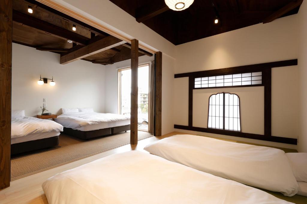 1 dormitorio con 2 camas y ventana en 貸別荘 楓-Fū- 有馬 en Arimachō
