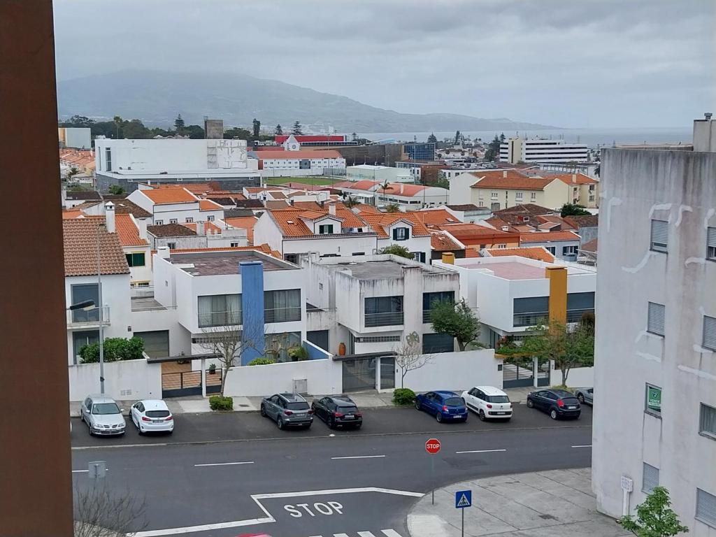 uma vista para uma cidade com carros estacionados num parque de estacionamento em Paim Maria em Ponta Delgada