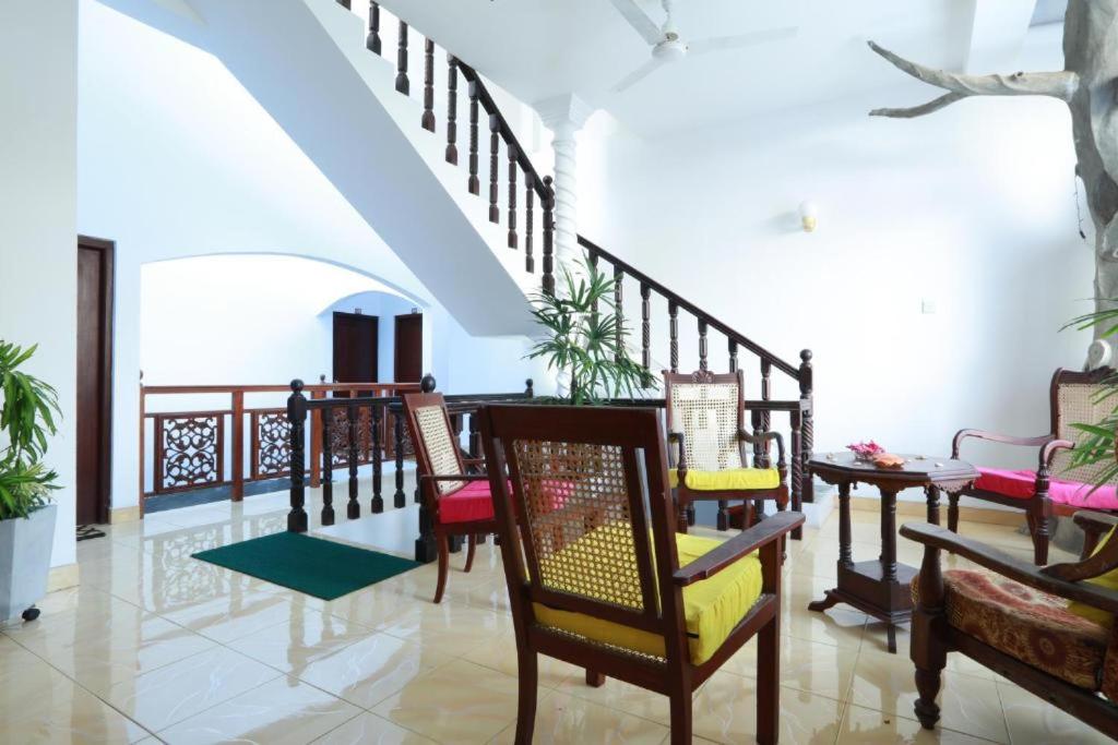 a living room with chairs and a staircase at Limitless in Sri Jayewardenepura Kotte