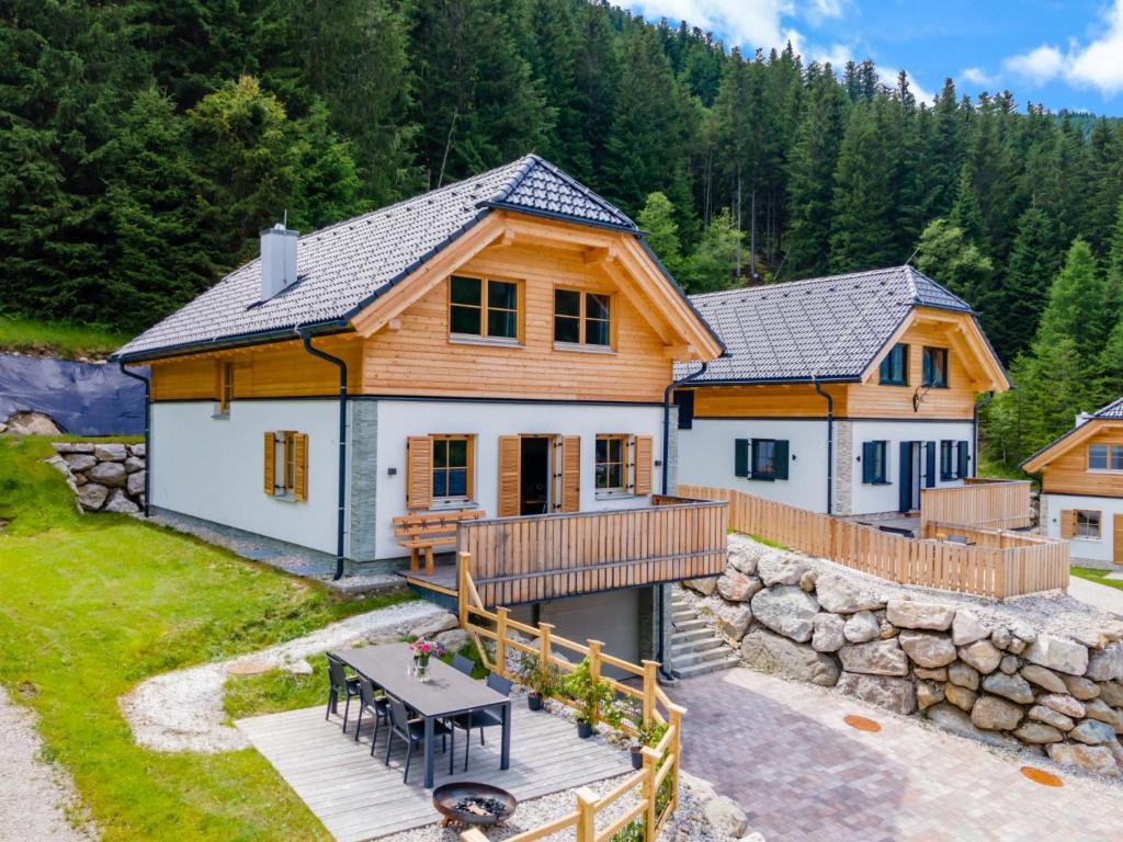 a log home with a deck and a house at Vita Montagna in Donnersbachwald