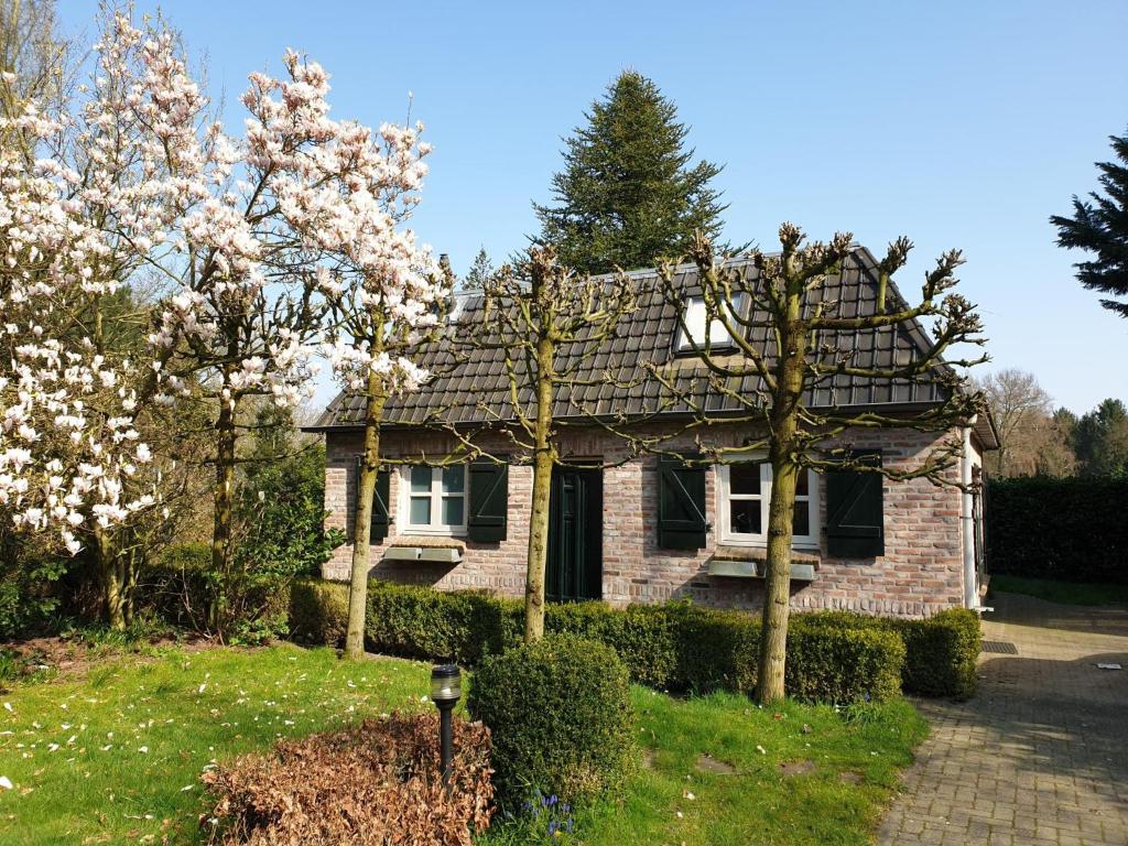 a brick house with trees in front of it at Broeksteeg in Haaren