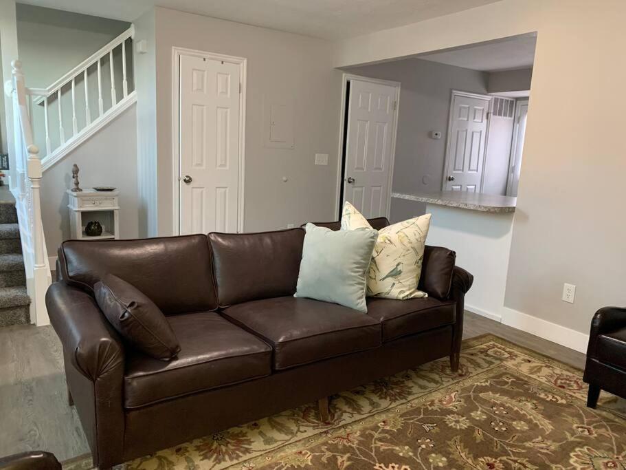 um sofá de couro castanho numa sala de estar em Rooms with a Mountain View em Pleasant Grove