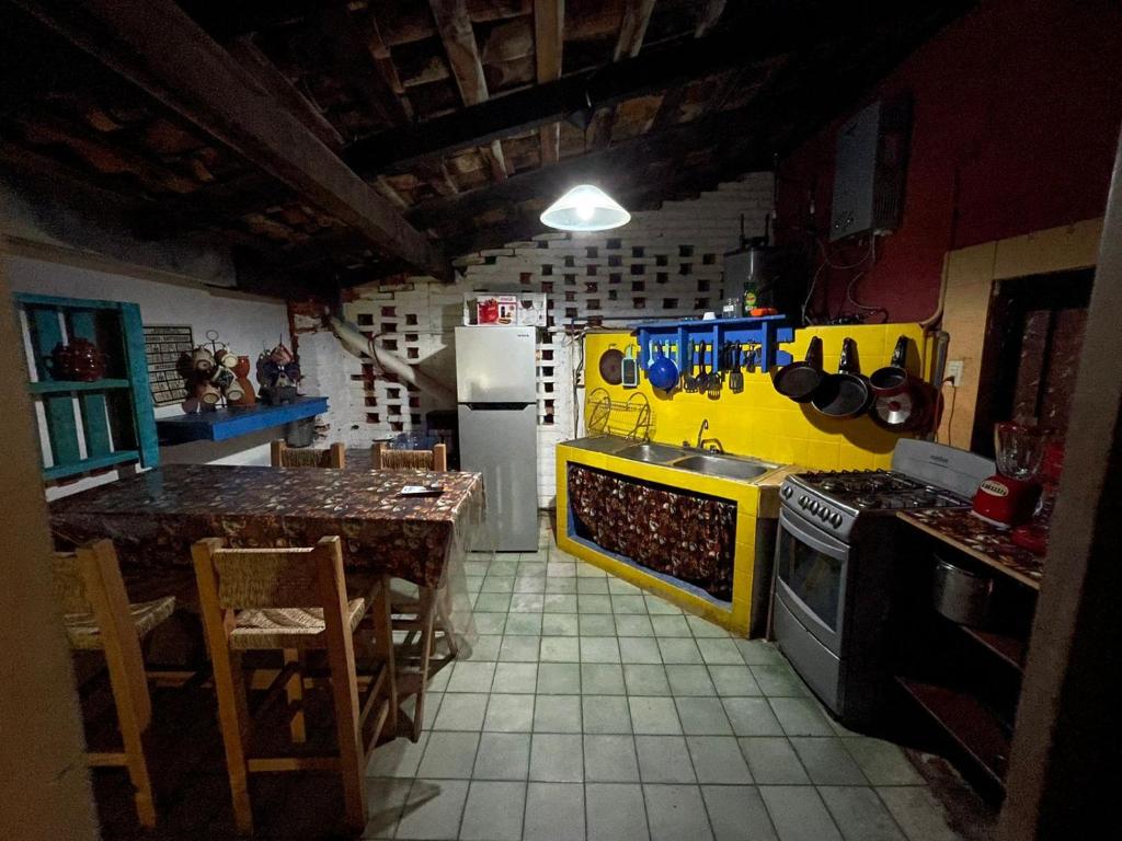 une cuisine avec une table et un réfrigérateur dans l'établissement Casa frida a 2 minutos del malecón, à Puerto Vallarta