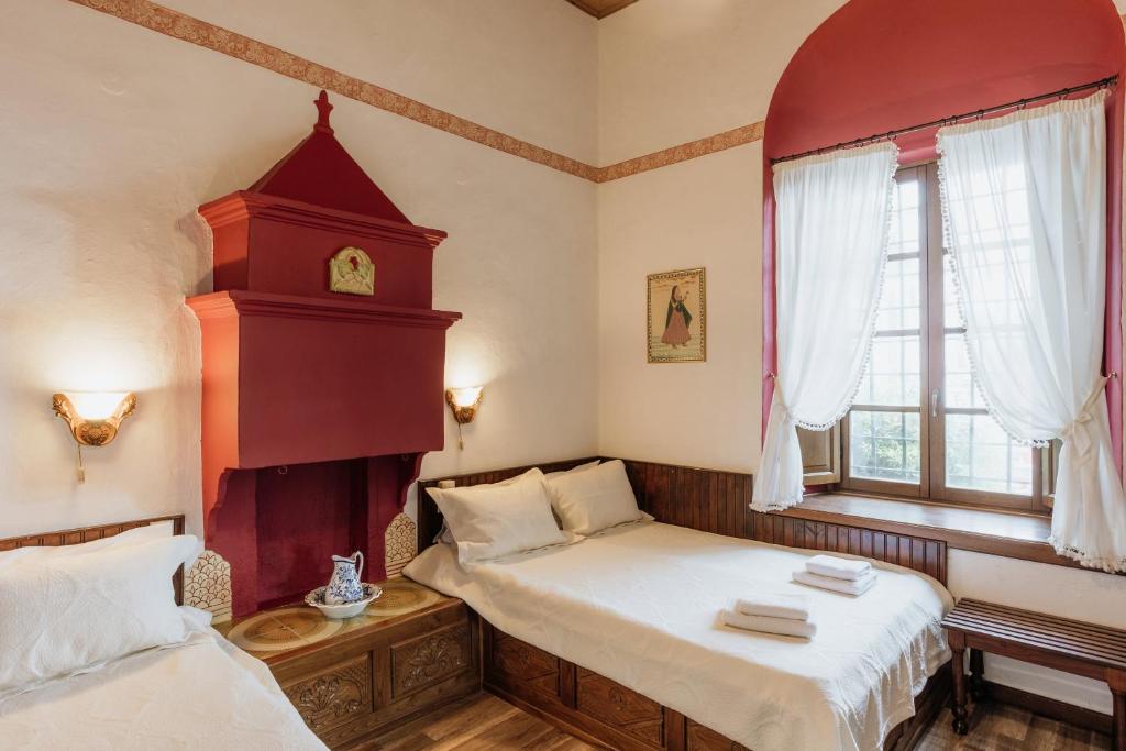 ポルタリアにあるArchontiko Kantartziのベッドルーム1室(ベッド2台、壁掛け時計付)