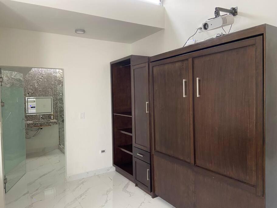 a bathroom with a wooden cabinet and a sink at Loft, Departamento Con cocina, Súper Lujo, Cuarzo in Monterrey
