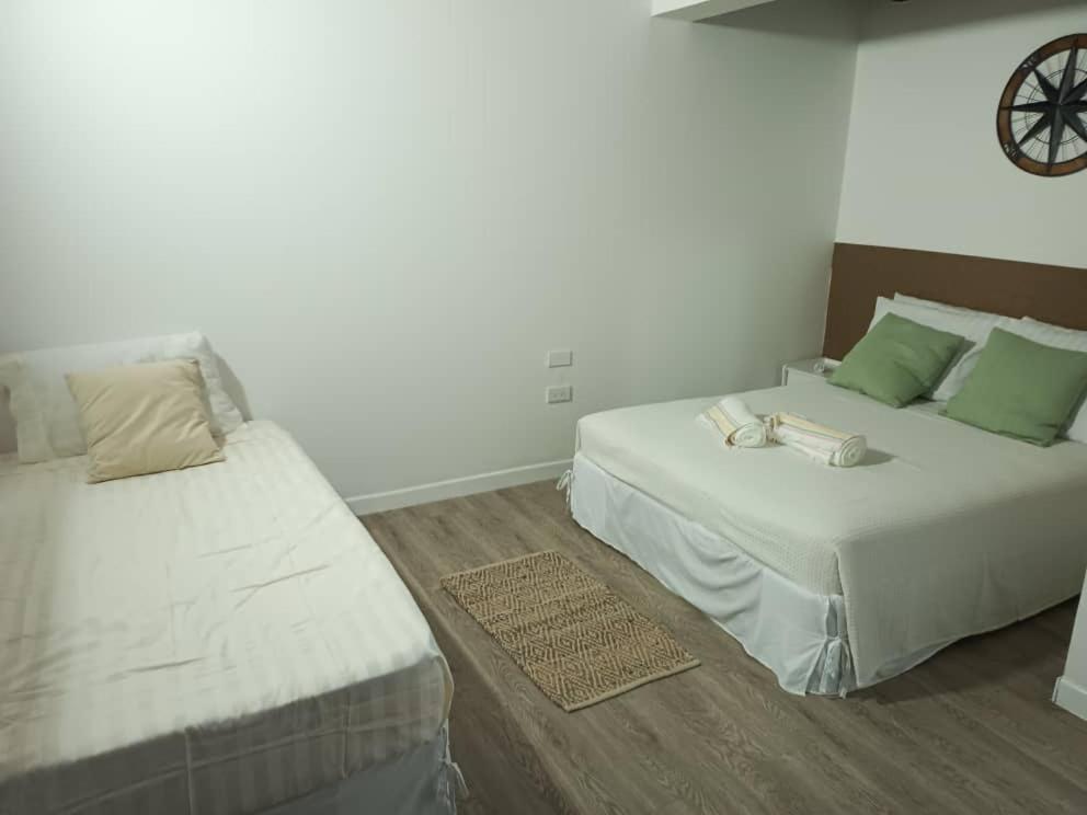 1 dormitorio con 2 camas y reloj en la pared en Casa Wadara en La Mira
