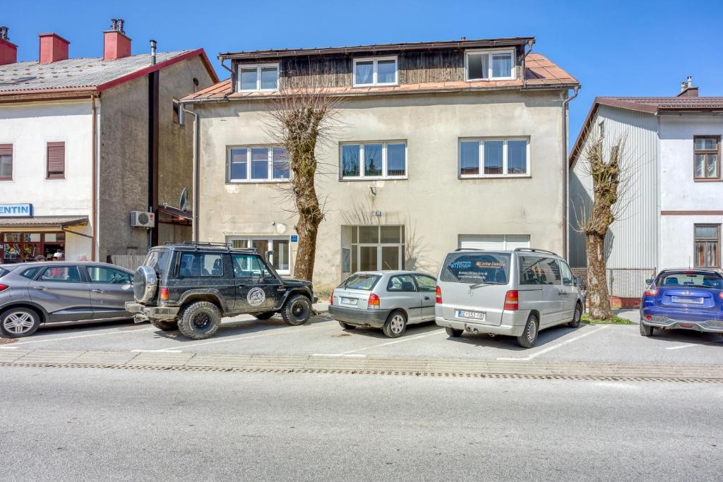 un groupe de voitures garées sur un parking devant un bâtiment dans l'établissement Apartments with a parking space Delnice, Gorski kotar - 23045, à Delnice