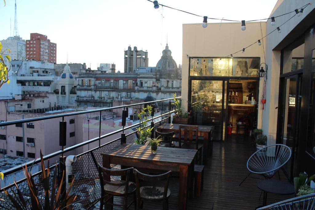 a balcony with tables and chairs and a view of a city at Parla Hostel in Buenos Aires