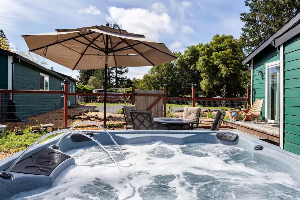 bañera de hidromasaje con sombrilla en un patio en Charming dog-friendly home next to regional park en Sebastopol
