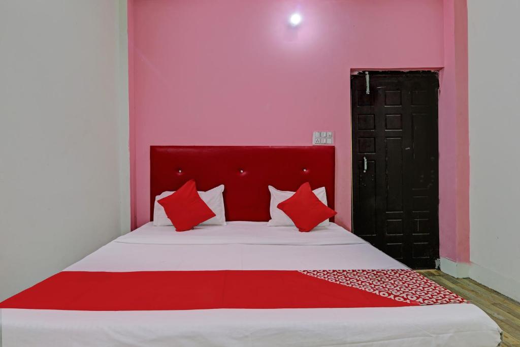 - un lit avec des oreillers rouges dans l'établissement OYO Flagship Relax Stay In, à Lucknow