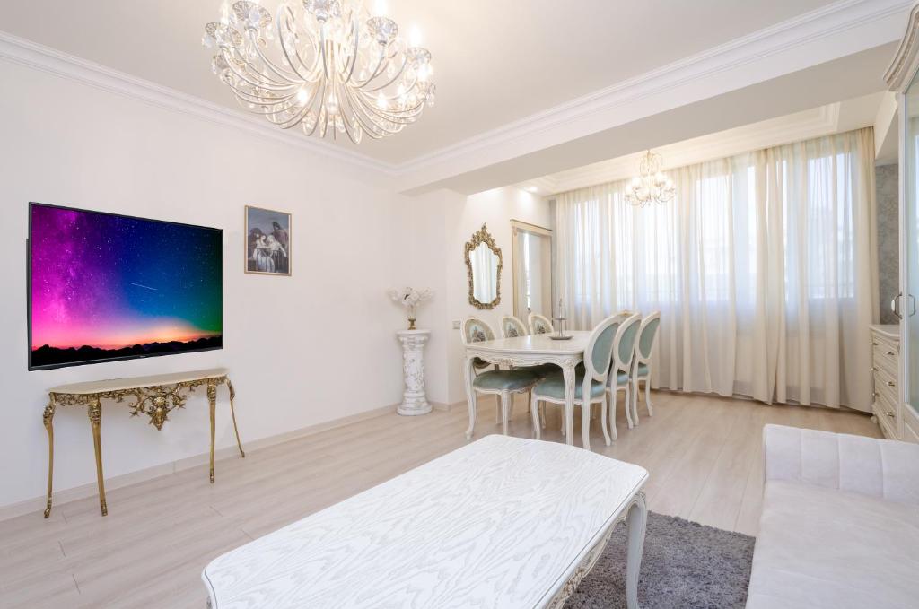 Sala de estar blanca con mesa y lámpara de araña en 5A beautiful apartment in the center of the capital photo original, en Ereván