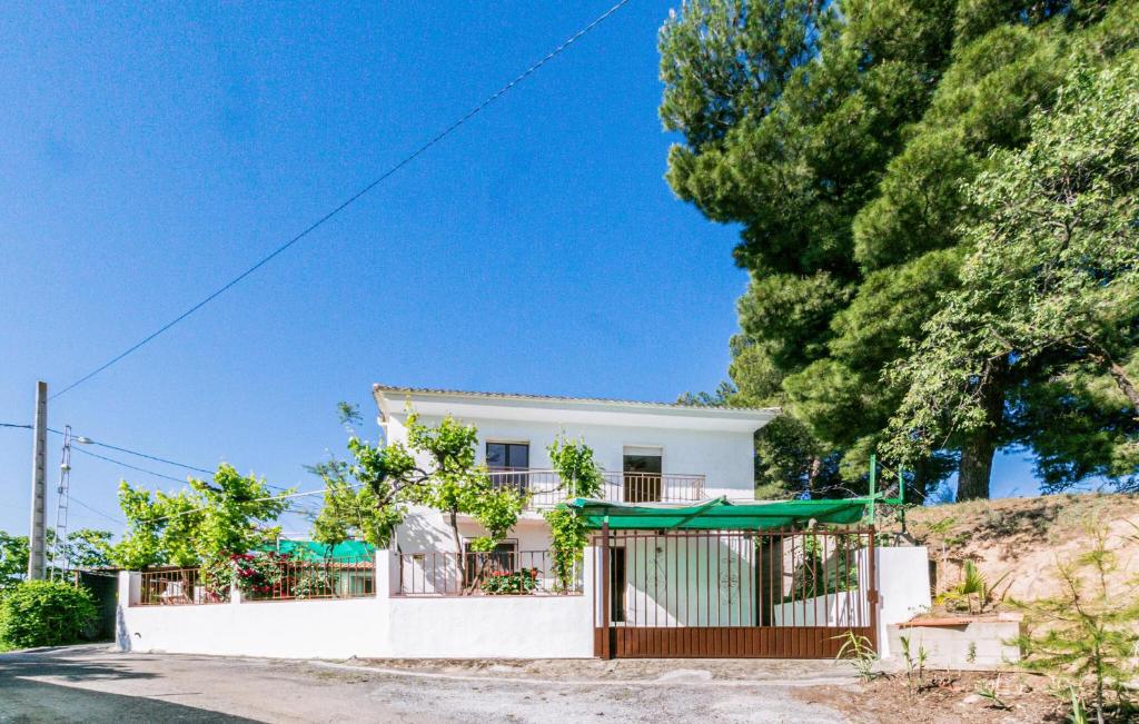 une maison blanche avec une clôture et des arbres dans l'établissement Nice Home In Alcala La Real With Kitchen, à Alcalá la Real