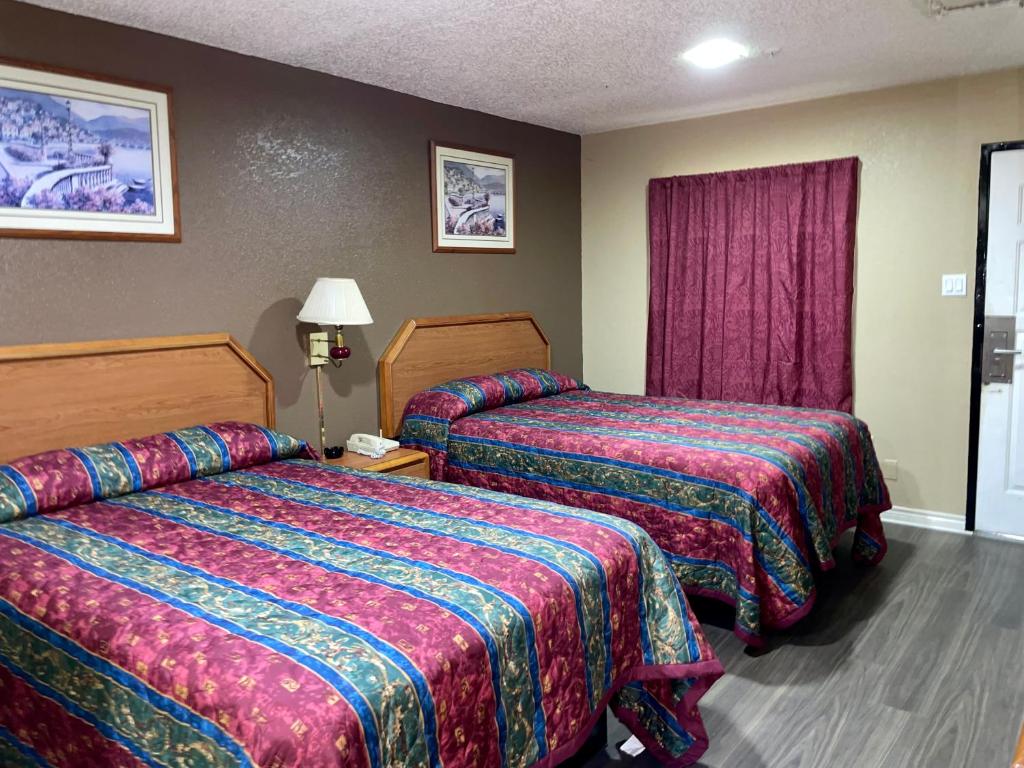 a hotel room with two beds and a window at Ankur Inn Motel in Dallas