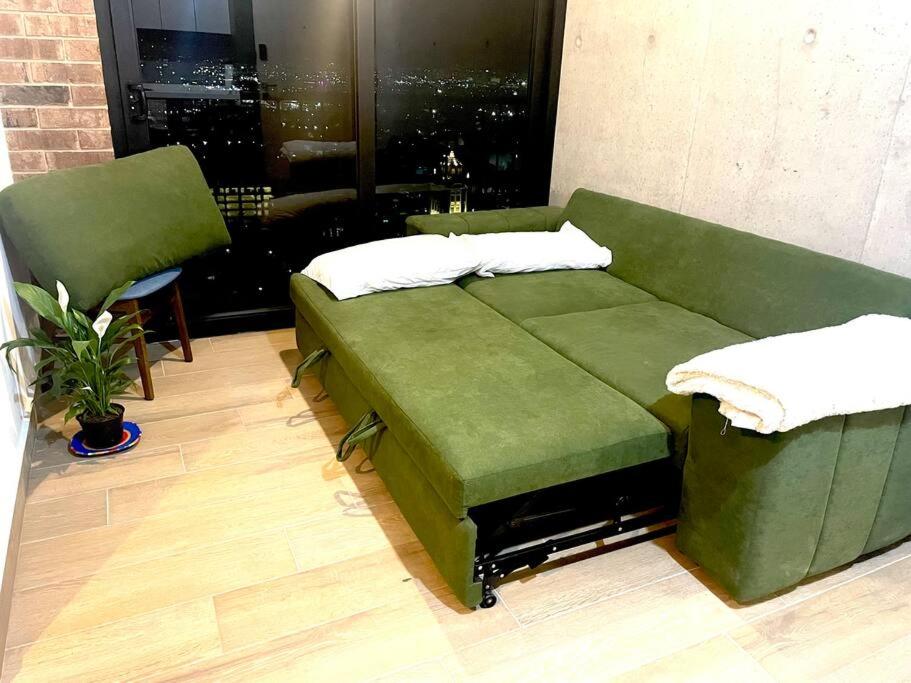 un sofá verde en una habitación con ventana en Entire apartment with unique view at the best location, en Monterrey