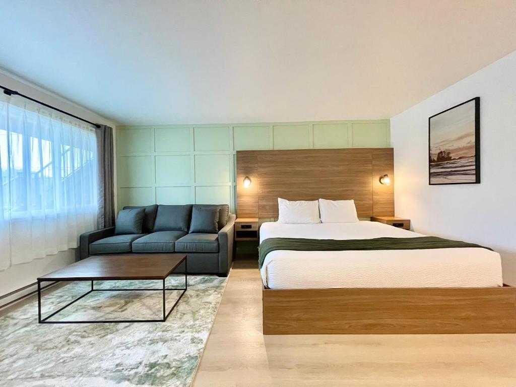 ein Hotelzimmer mit einem Bett und einem Sofa in der Unterkunft Ukee Peninsula Motel in Ucluelet