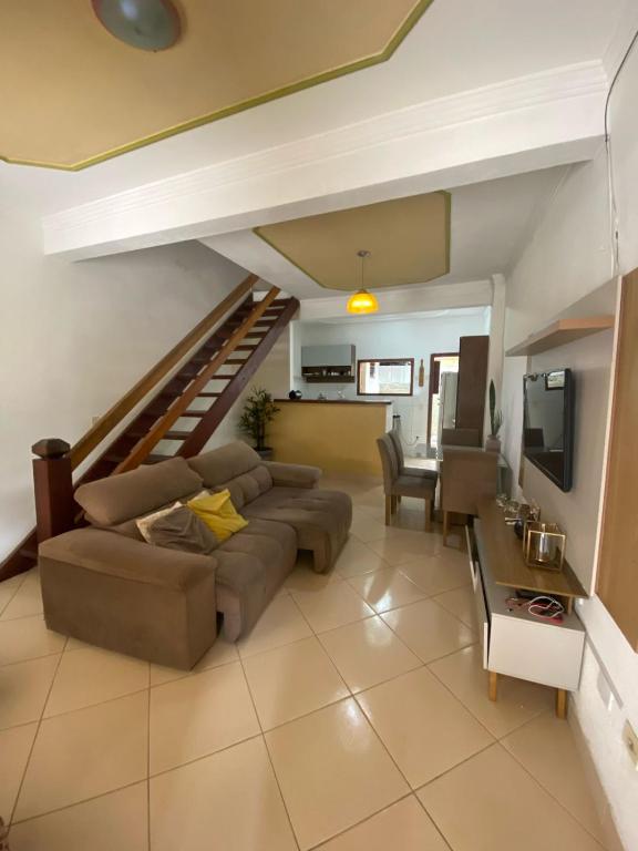 a living room with a couch and a staircase at Casa temporada em Paraty RJ in Paraty