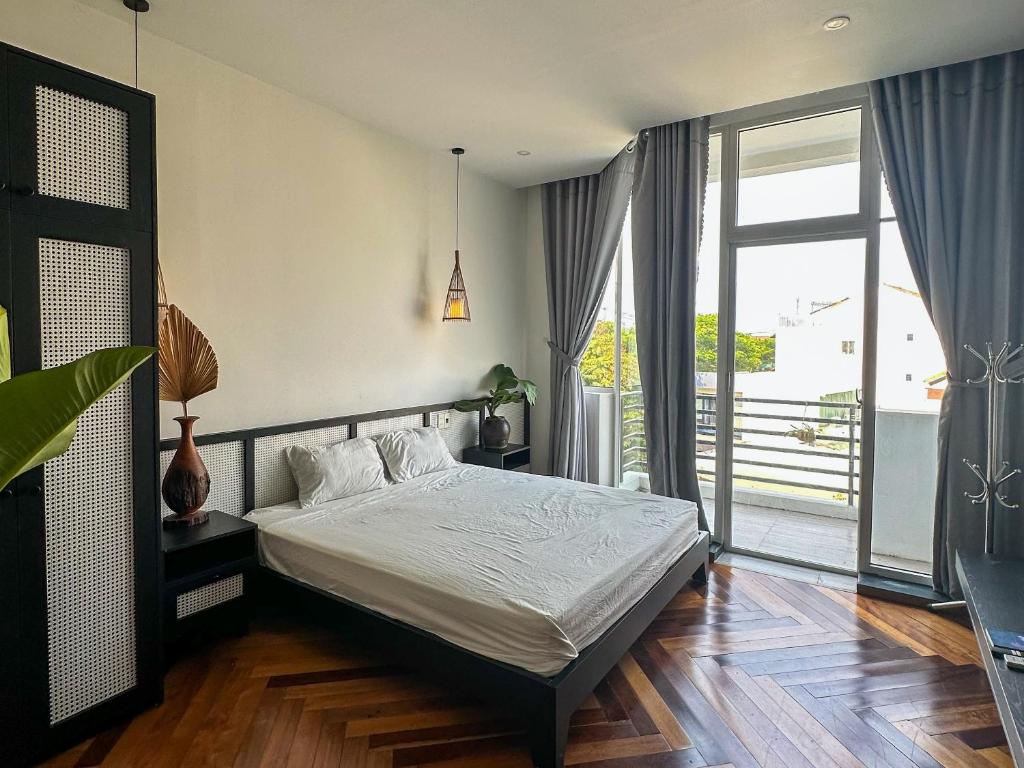 ein Schlafzimmer mit einem Bett und einem Balkon in der Unterkunft Ben's House Hoi An in Hoi An