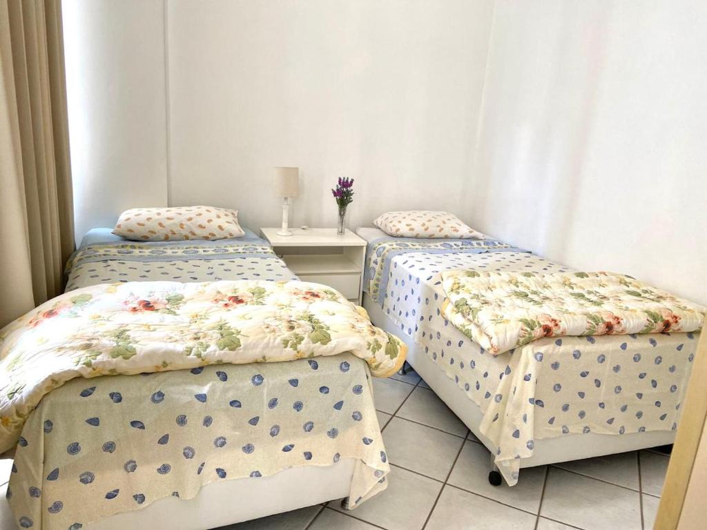 Hotel Apartamento charme de Ipanema, a bedroom with two beds and a table with a nightstand at Apartamento charme de Ipanema in Rio de Janeiro