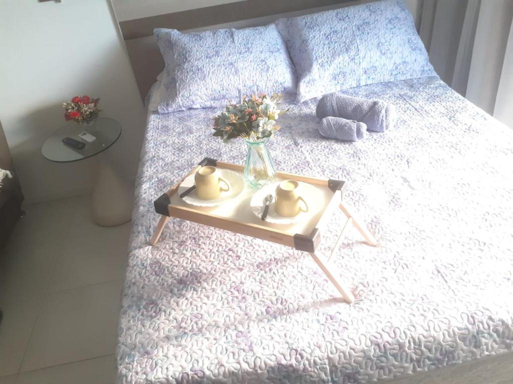 a bed with a table with two ducks on it at Loft Praia de Armação in Salvador