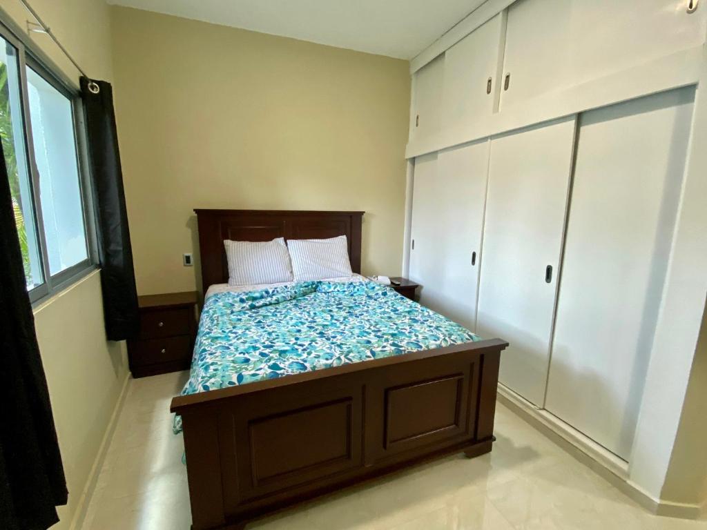 a bedroom with a bed in a room with white cabinets at Elegante Apartamento A 100 mts la playa de los Minos RSJ in Río San Juan
