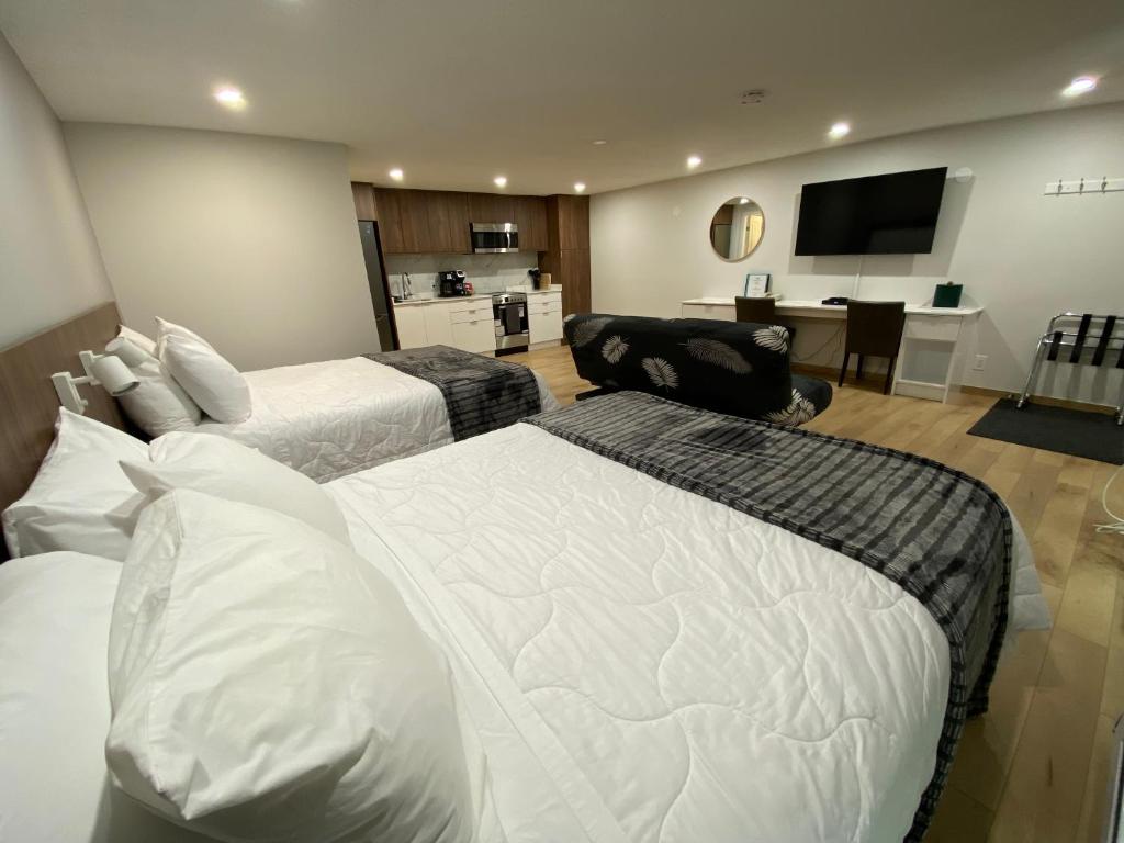 a hotel room with two beds and a television at Western Traveller Motel in Grand Forks