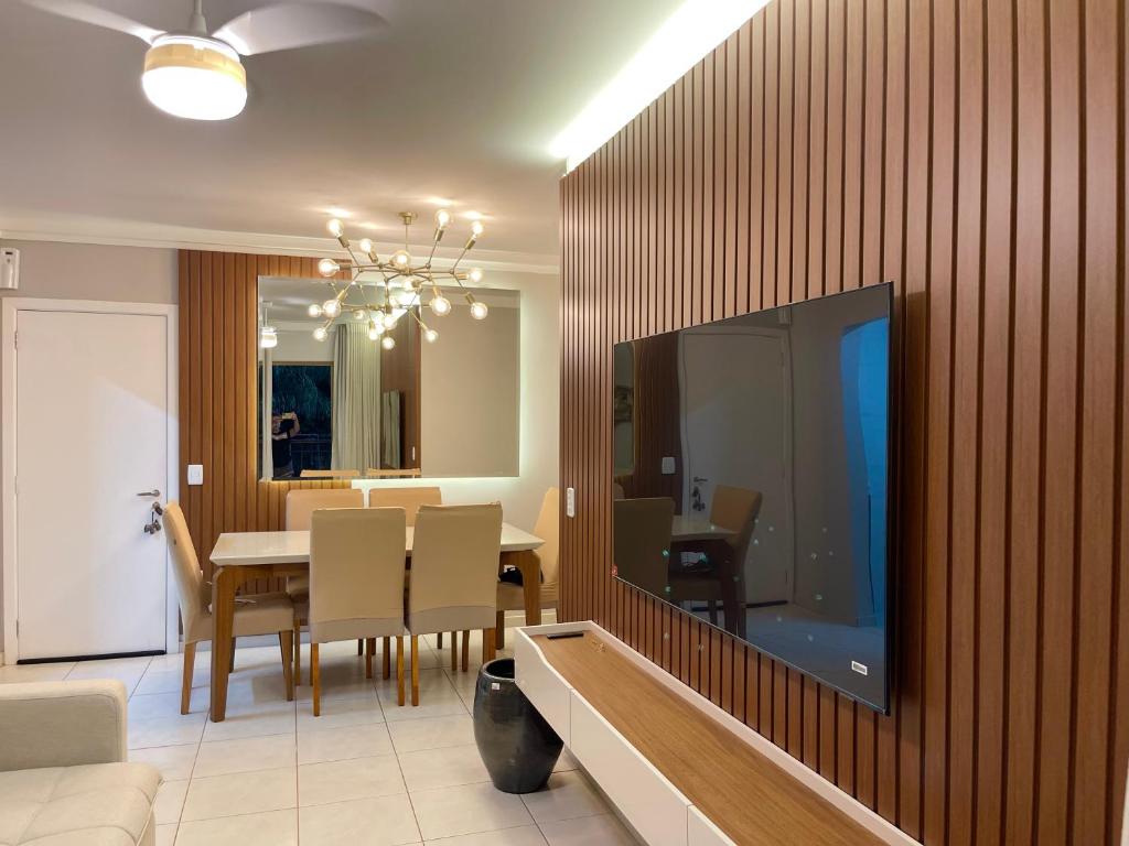 a dining room with a table and a television on a wall at Apartamento em Nova Aliança in Ribeirão Preto