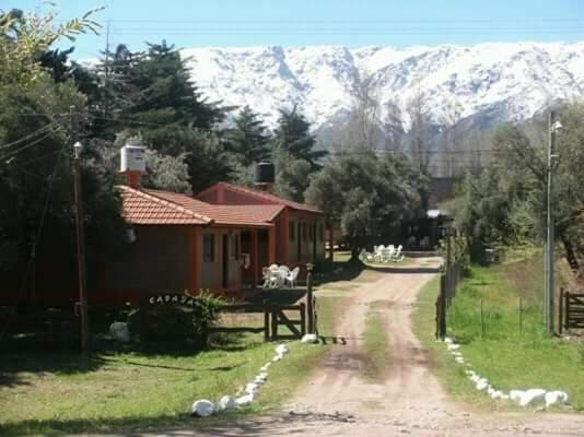 una casa en un camino de tierra delante de una montaña en Cabañas San Nicolas en Carpintería