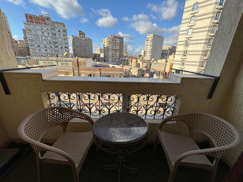a table and two chairs on a balcony with a view at Charming Downtown Apartment in Alexandria