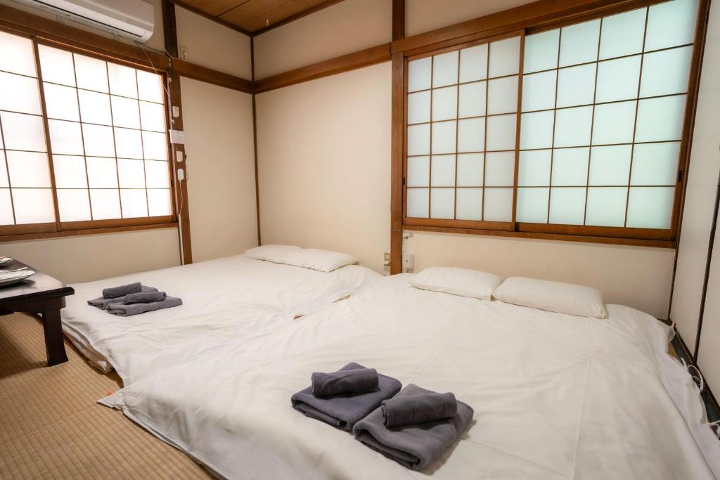 two beds in a room with towels on them at 五十岚民宿 地铁站步行4分 免费高速 WI-FI TraditionCozy Japanese Villa in Ikebukuro 6mins St with Hight speed WIFI in Tokyo