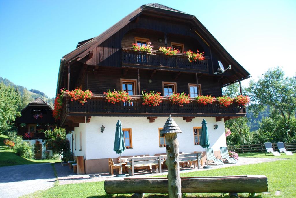 a house with a balcony with flowers on it at Ferienwohnung Lahnerhof in Arriach