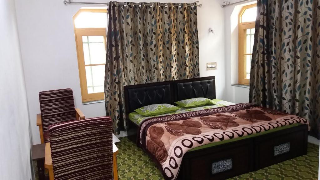 a bedroom with a bed and a window with curtains at Al-Bilad Guest House in Srinagar