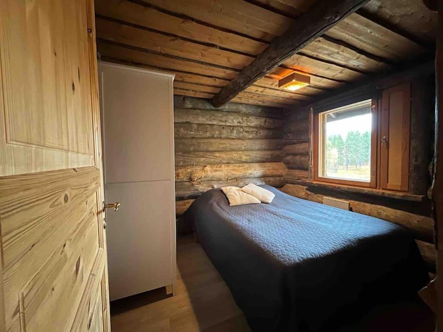 a bedroom with a bed in a log cabin at Keloparitalon loma-asunto Ylläs-näkymällä ja paljulla in Ylläsjärvi