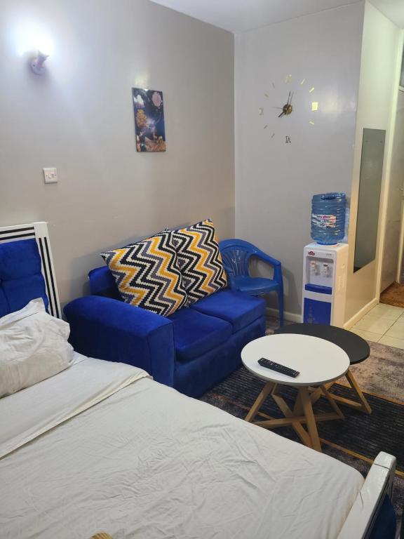 Habitación con cama, sofá y mesa. en Spacious and Affordable Studio en Nairobi