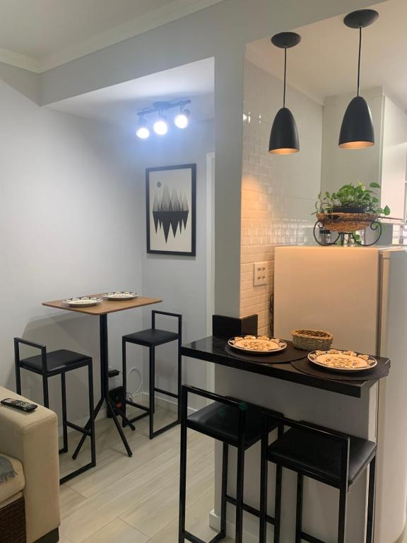 eine Küche mit zwei Tischen und Stühlen mit Essen drauf in der Unterkunft Apartamento em Santos na Ponta da Praia in Santos