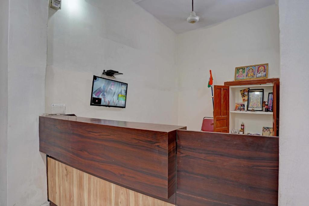 a reception desk with a tv on a wall at New Narayan Palace in Bhopal