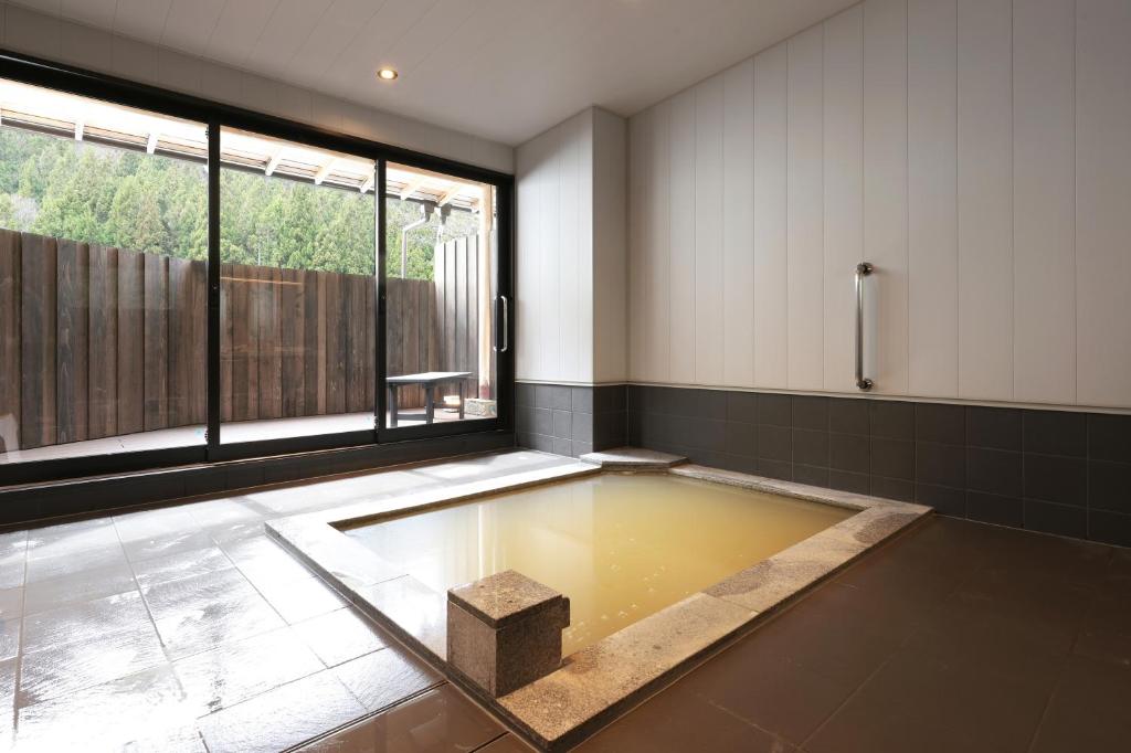 a bathroom with a pool of water on the floor at Akagi Onsen Hotel in Maebashi